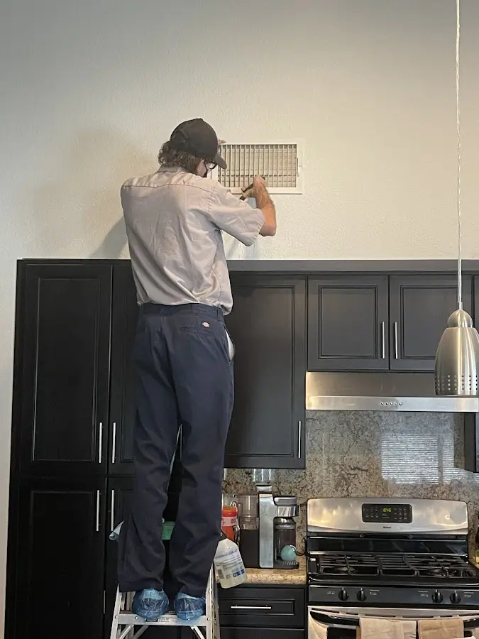Technician inspecting an air vent during HVAC service in Paterson